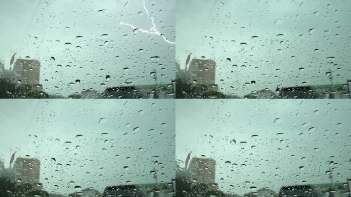 玻璃上的雨滴和天空中的闪电