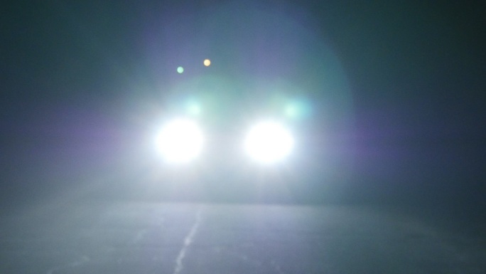 夜间开灯行驶的汽车。