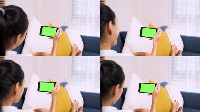 女人躺在沙发上看绿屏手机视频