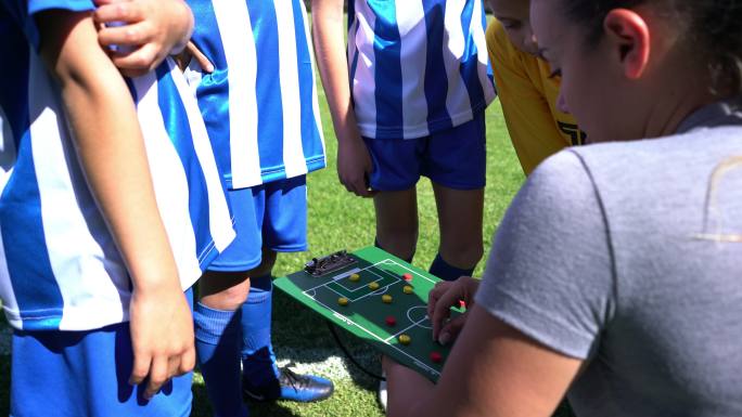 在足球训练中指导一群孩子的年轻女子