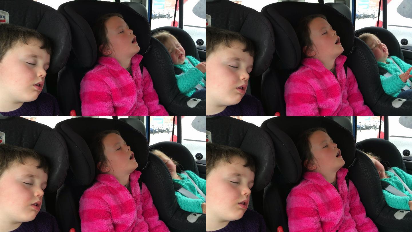 长途旅行后睡在车后座的孩子们