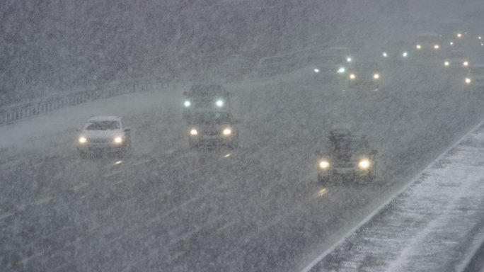 暴风雪中在高速公路上行驶的汽车