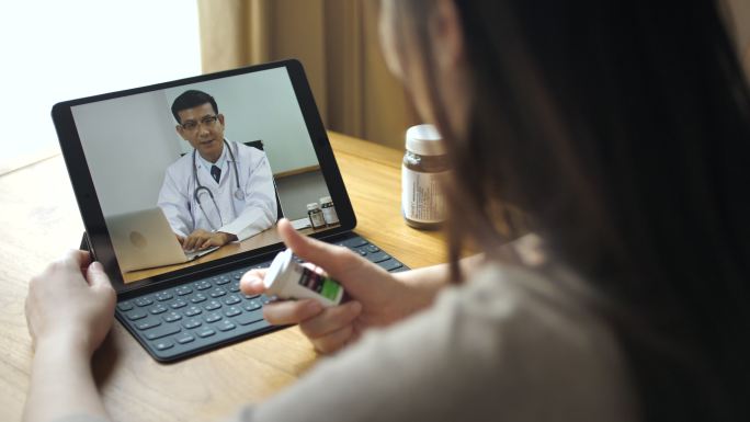 生病女子在家用平板电脑与医生视频对话