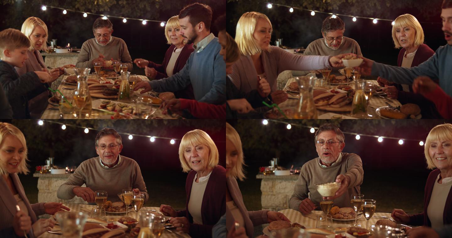 一家人晚上在野餐桌上吃饭