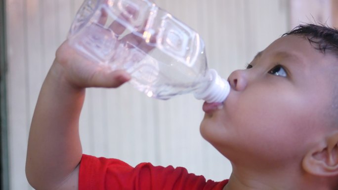 男孩喝瓶装水