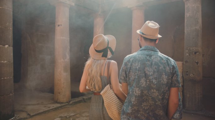 年轻夫妇参观古希腊石柱纪念碑