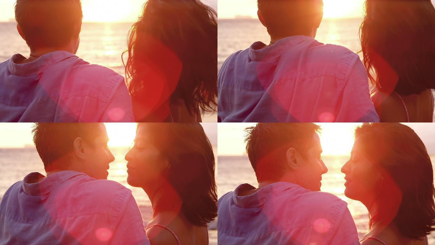 日落时分，一对年轻夫妇坐在海滩上亲吻