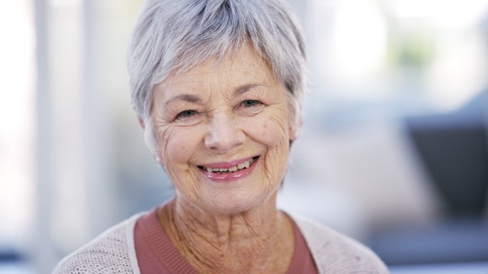 一个老年女性正冲着镜头微笑