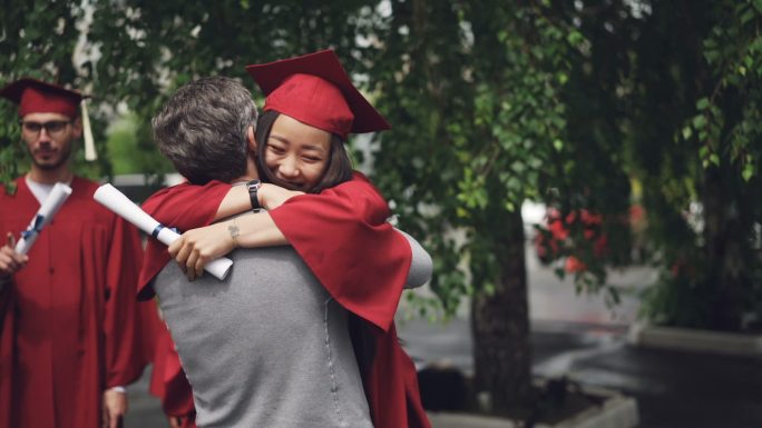 即将毕业的学生抱着她慈爱的父亲