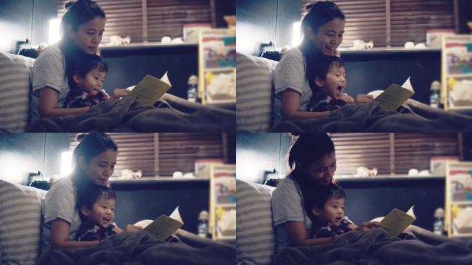 妈妈和小儿子晚上在床上看书。