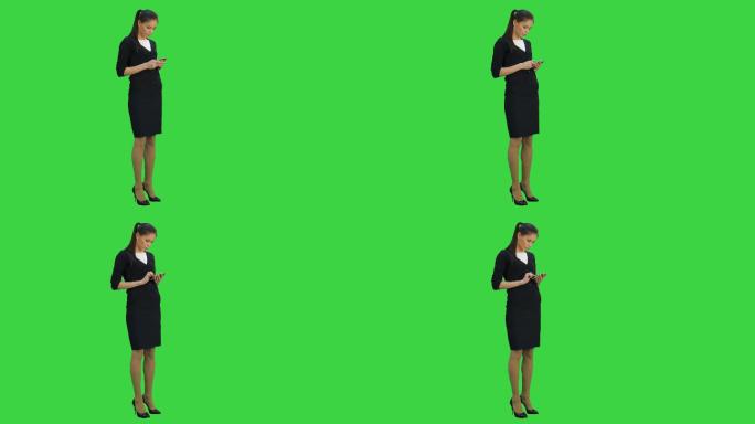 女人一边看手机，一边走在绿色屏幕上