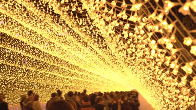 日本名古屋冬季夜晚大黄灯照明的人群。