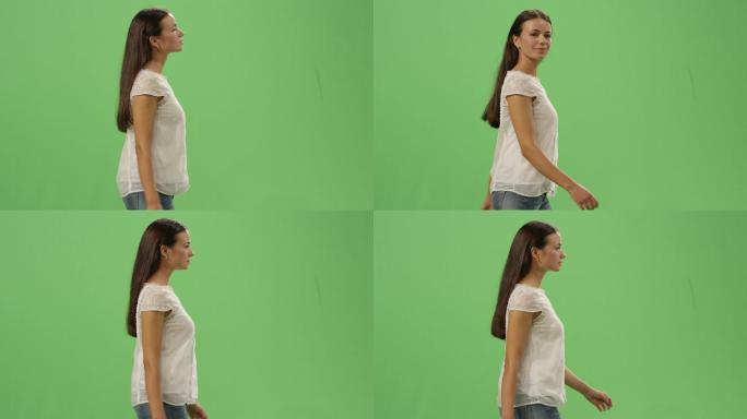 年轻女孩走在模拟绿色屏幕的背景上。