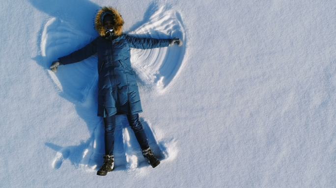 女人在雪地里做雪天使