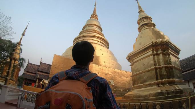 游客背着背包走进寺庙