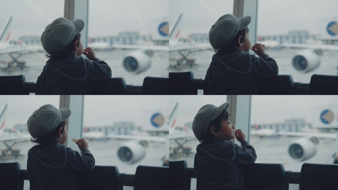 一个小男孩在机场看飞机。