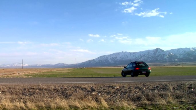 一辆汽车在美丽的山谷里的高速公路上掉头转