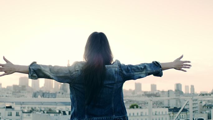 屋顶上的年轻女子纸飞机放飞梦想启航远航未