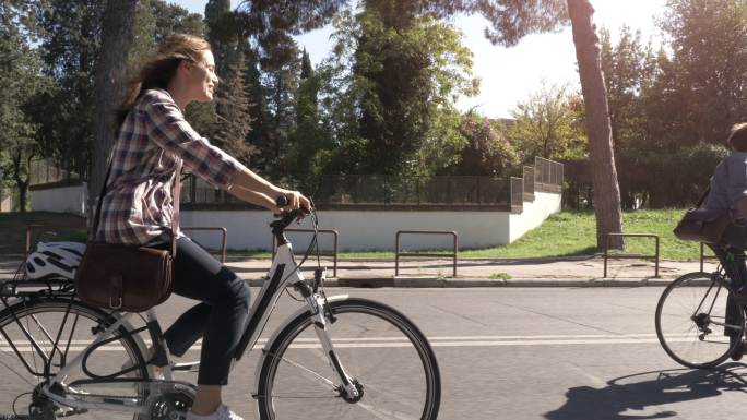 三位年轻人骑着自行车在街道上