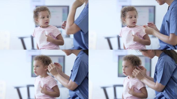 医生给小女孩带上助听器