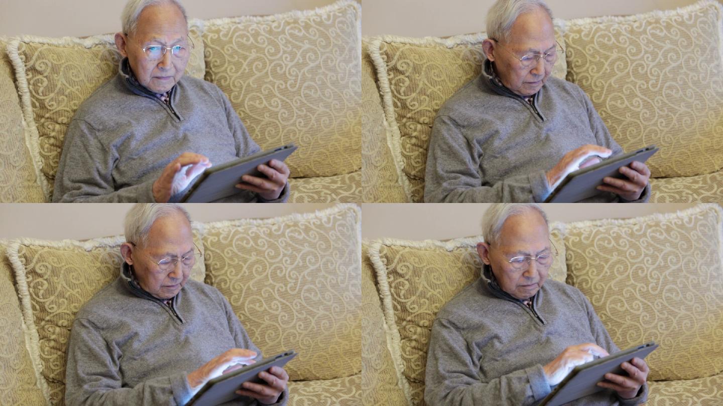 老人坐在沙发上使用数字平板电脑