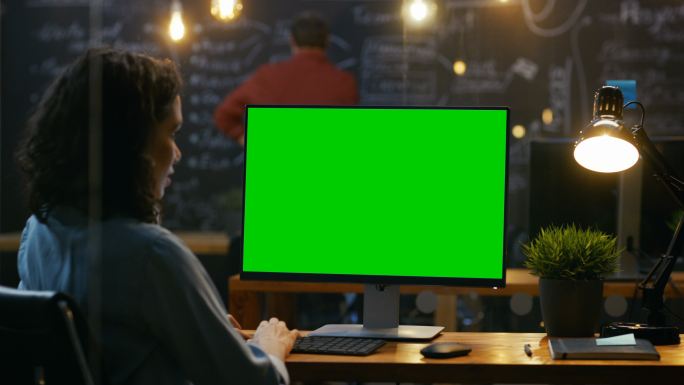办公室职员在一台模拟的绿色屏幕电脑上工作
