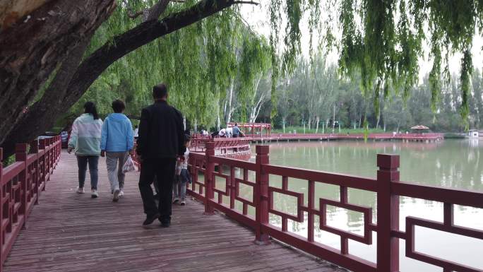 游人漫步湖畔景观桥