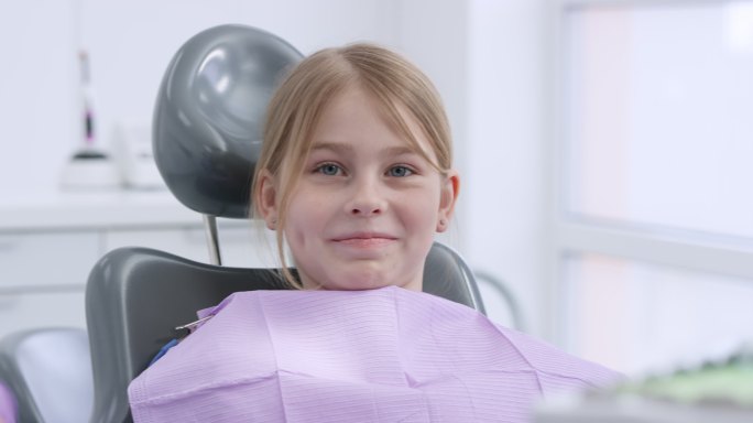 坐在牙科椅上微笑的女孩