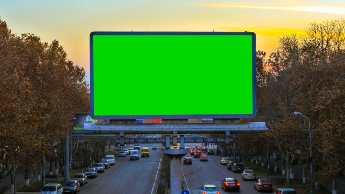 快速行驶的汽车背景上带有绿屏的广告牌。