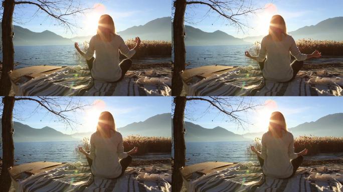 日落时在湖边练瑜伽的年轻女子