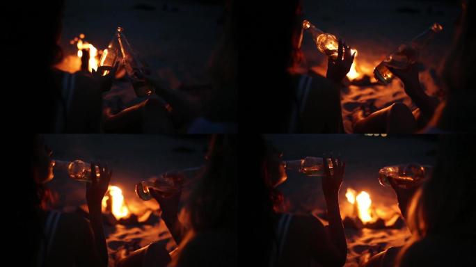 日落篝火海滩派对干杯碰杯海边两位女性