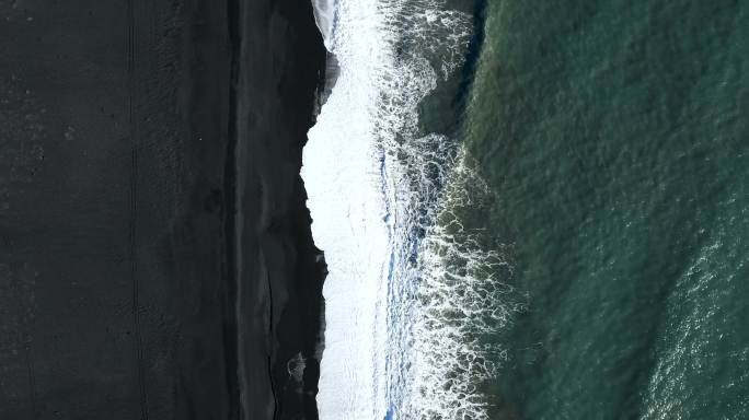 海浪在黑色海滩上飞溅
