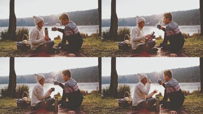 一对夫妇在湖边喝热咖啡
