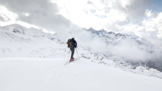 滑雪旅游者在山顶眺望远方