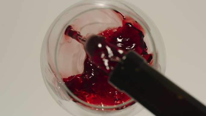 慢动作：把红酒从瓶子里倒进玻璃杯顶视图