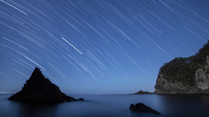 日本伊豆半岛海岩夜空的时间点星迹镜头