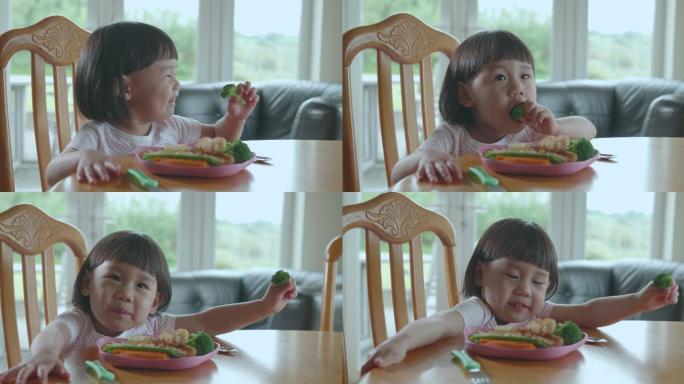 学步女孩在家吃花椰菜