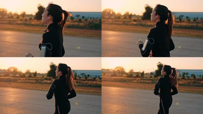 戴着耳机在日落时分奔跑的女人