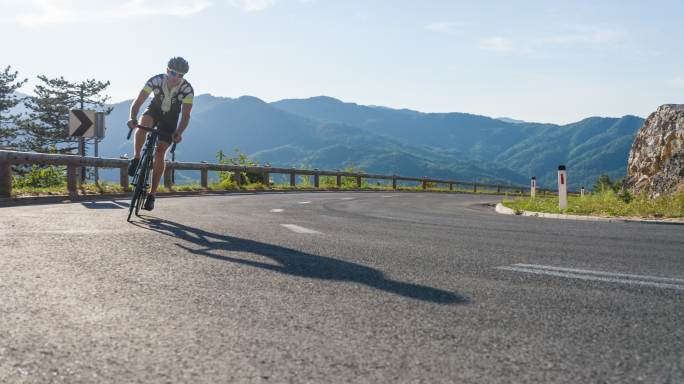 公路自行车手在蜿蜒的道路上转弯