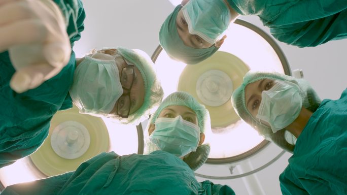 医生穿着手术服在手术室里看着病人