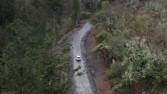 泥泞崎岖山路上行驶的警车