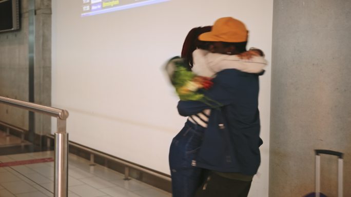 航班抵达后，男友在机场问候和拥抱女友