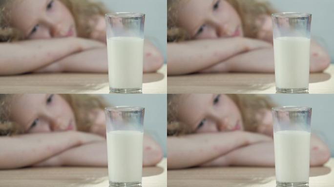 乳糖不耐的孩子伤心地看着一杯新鲜的白牛奶