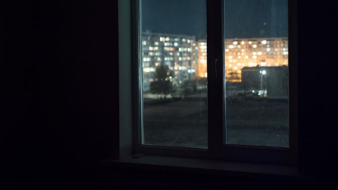 透过窗户看夜晚高层建筑