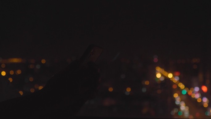 4K夜晚窗边看手机城市夜景
