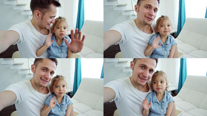 快乐的爸爸和小女孩向镜头挥手
