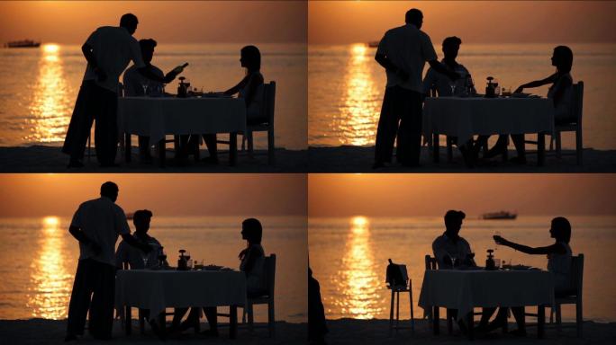 夕阳下在海边约会的情侣