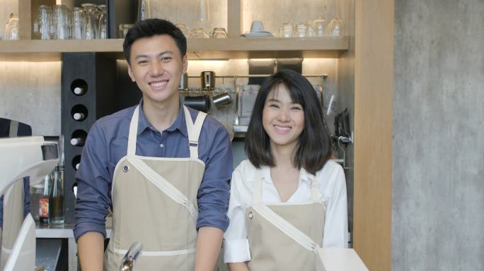 两位年轻的咖啡师在镜头前微笑