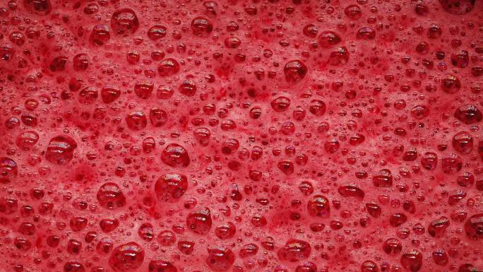 红色泡沫的特写镜头，无数的泡沫弹出