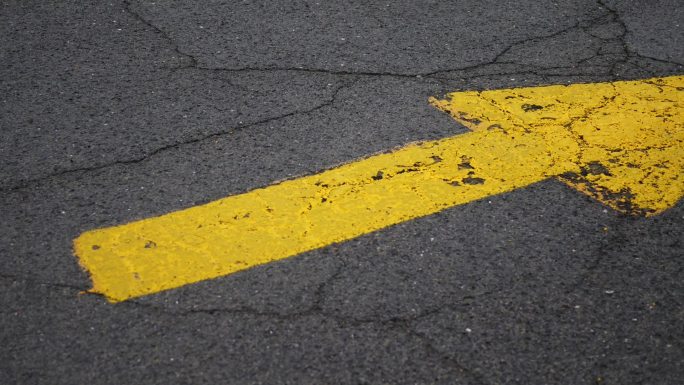 道路上指向停车场入口的黄色箭头